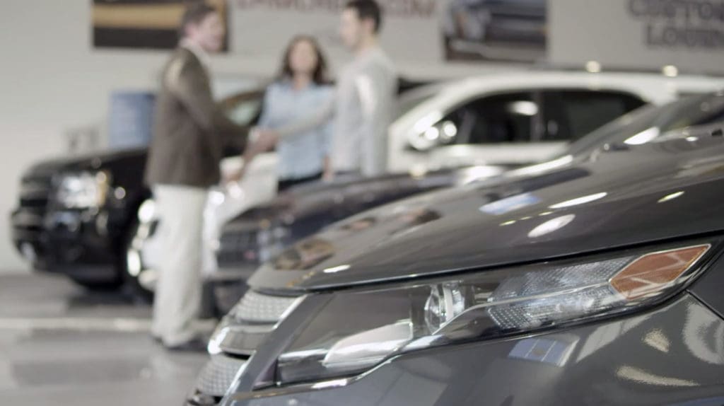 Employee talking to customers at a dealership