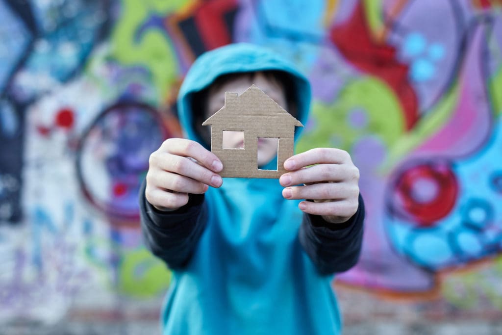 Boy holding cutout of house